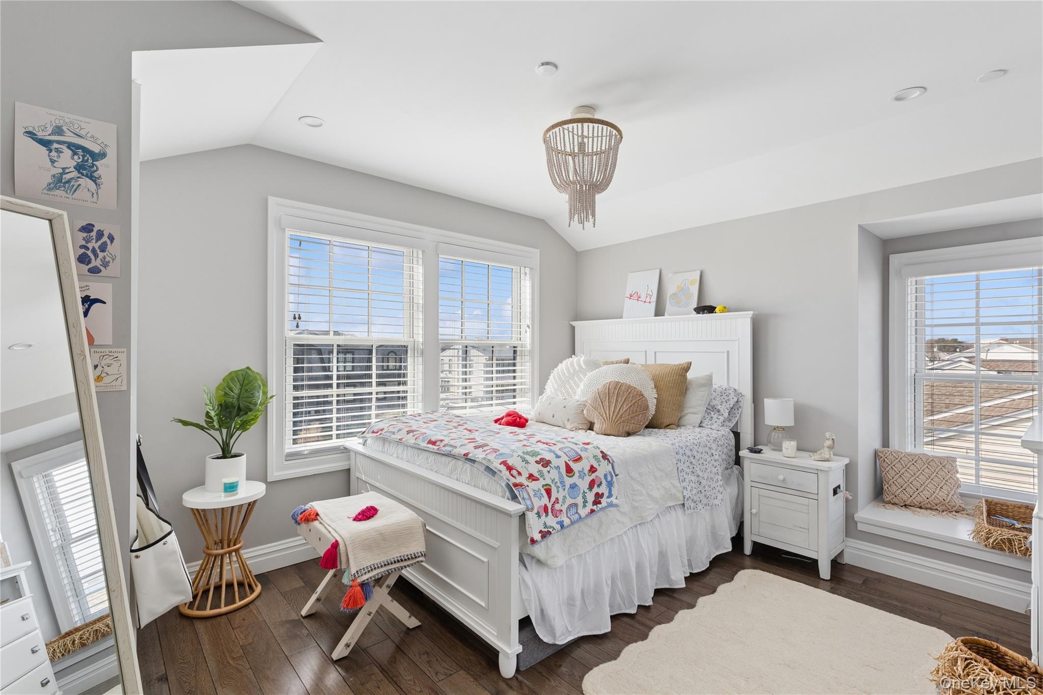 39 Shinnecock Road East Quogue, NY 11942 - Photo 28 of 35 a bedroom with a bed and a chandelier