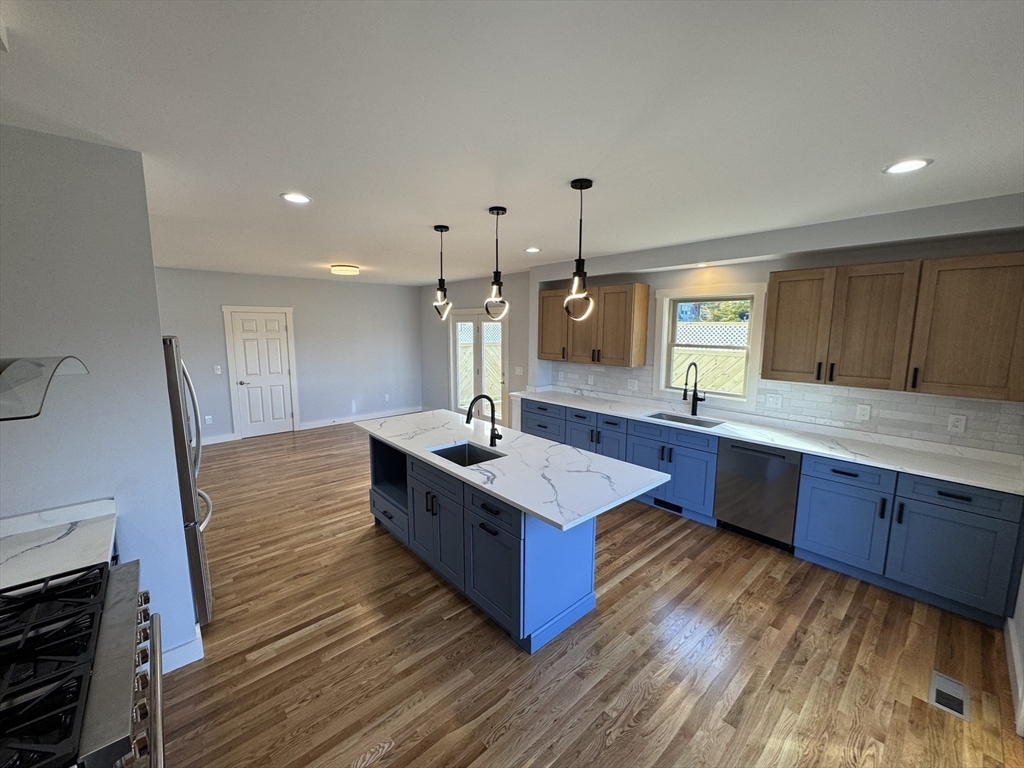 41 Westminster Street Worcester, MA 01605 - Photo 12 of 32 a large kitchen with wooden floors and stainless steel appliances