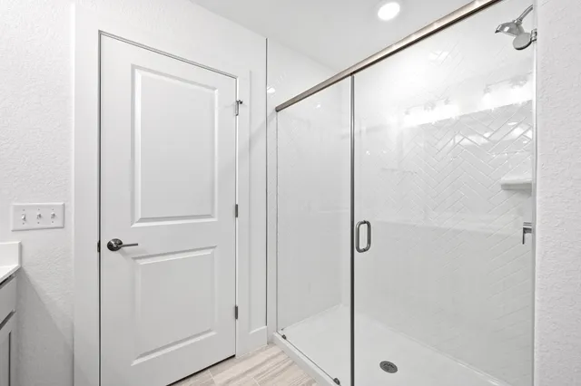 a bathroom with a sink a toilet a mirror and shower