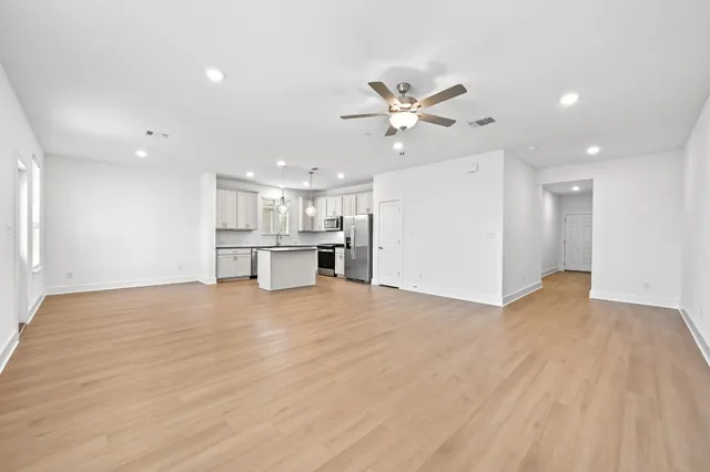 a view of empty room with wooden floor and window