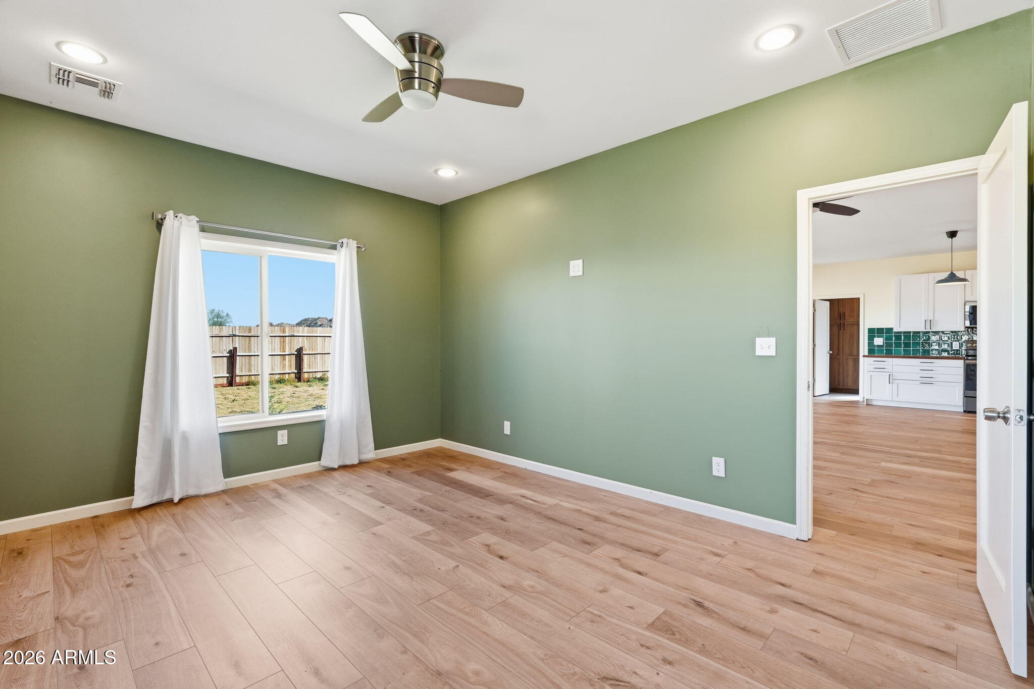 1289 South Oak Road Maricopa, AZ 85139 - Photo 18 of 39 a view of a livingroom with wooden floor and a ceiling fan