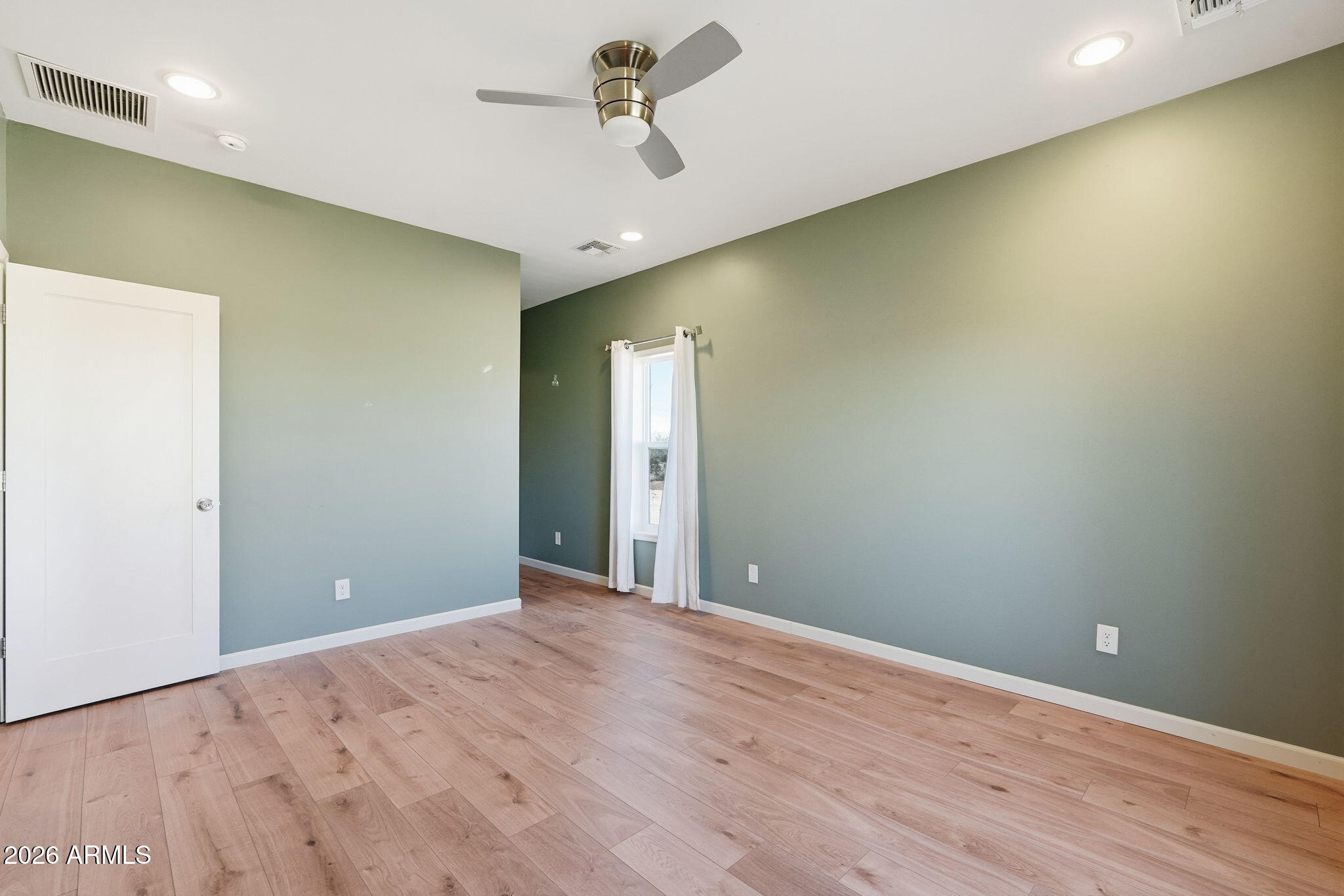 1289 South Oak Road Maricopa, AZ 85139 - Photo 19 of 39 a view of an empty room with wooden floor