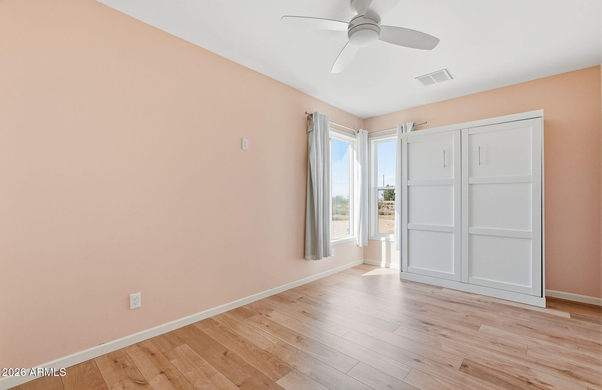 1289 South Oak Road Maricopa, AZ 85139 - Photo 7 of 39 a view of an empty room with wooden floor
