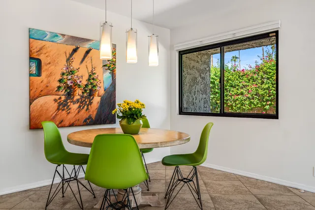 a view of a dining room with furniture a rug and a large window