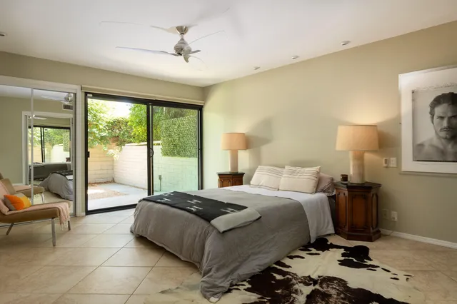 a bedroom with a bed and large windows