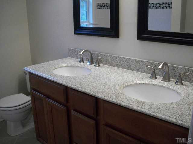 8131 Covered Bridge Road Wendell, NC 27591 - Photo 11 of 22 Breath taking master bathroom with granite dual vanity, ceramic tile flooring, upgraded cabinets, mirrors, light and plumbing fixtures. Master Bath/Spa