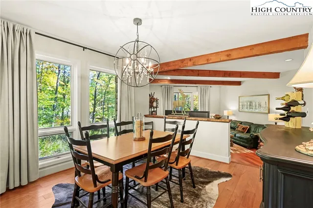 a dining room with furniture a chandelier and wooden floor