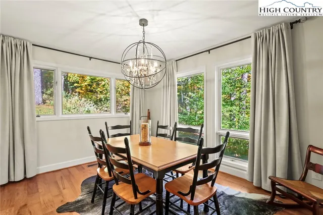 a view of a hallway with wooden floor and a bathroom
