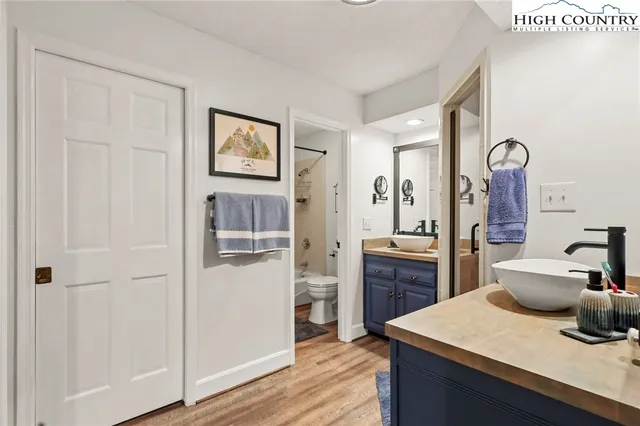 a bathroom with a granite countertop sink mirror and shower