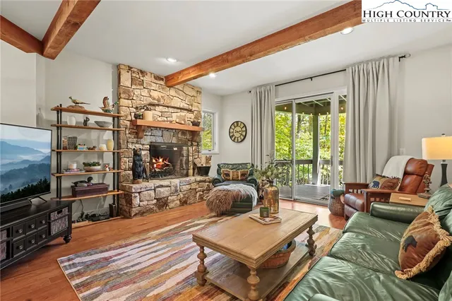 a kitchen with a sink appliances wooden floor and a large window