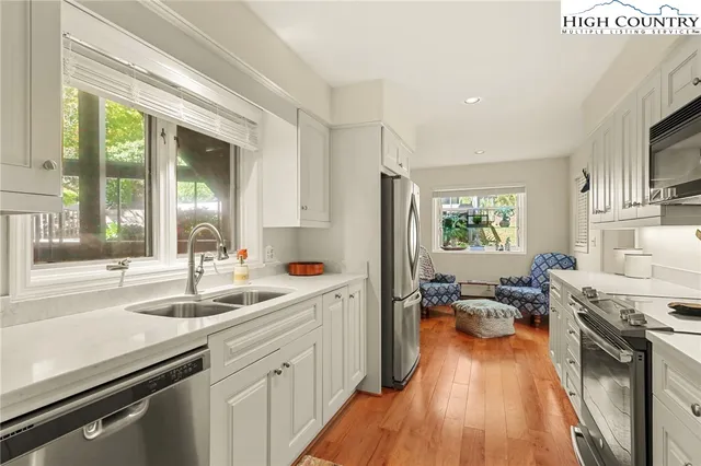 a kitchen with white cabinets and appliances