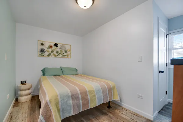 a bedroom with a bed and painting on the wall