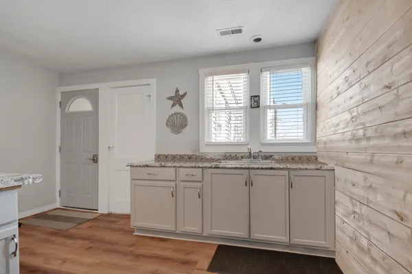 a bathroom with a granite countertop sink and a window