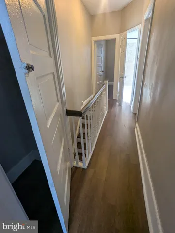 a view of a hallway with wooden floor and stairs