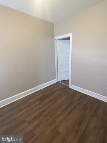 an empty room with wooden floor and closet