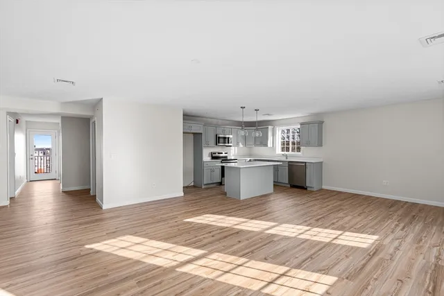 a view of a kitchen with a sink and dishwasher a refrigerator with wooden floor