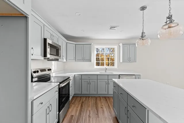 a kitchen with stainless steel appliances granite countertop a sink stove and refrigerator