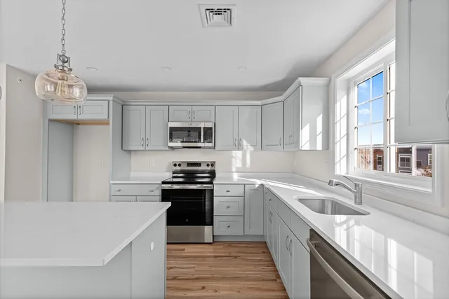 a kitchen with a chandelier and wooden floors