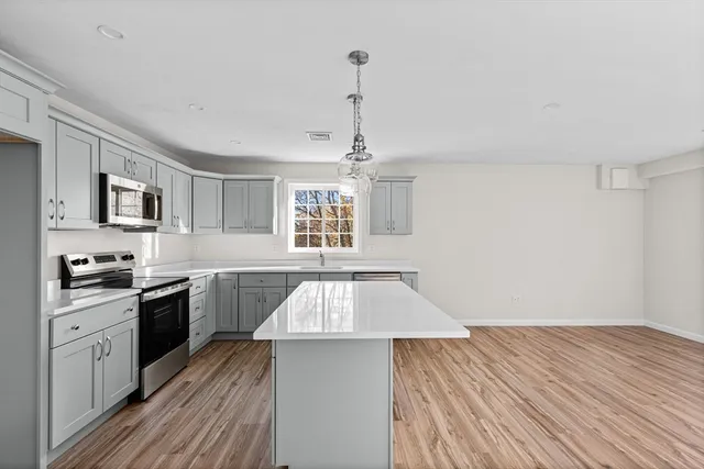 a view of a kitchen with wooden floor and a window