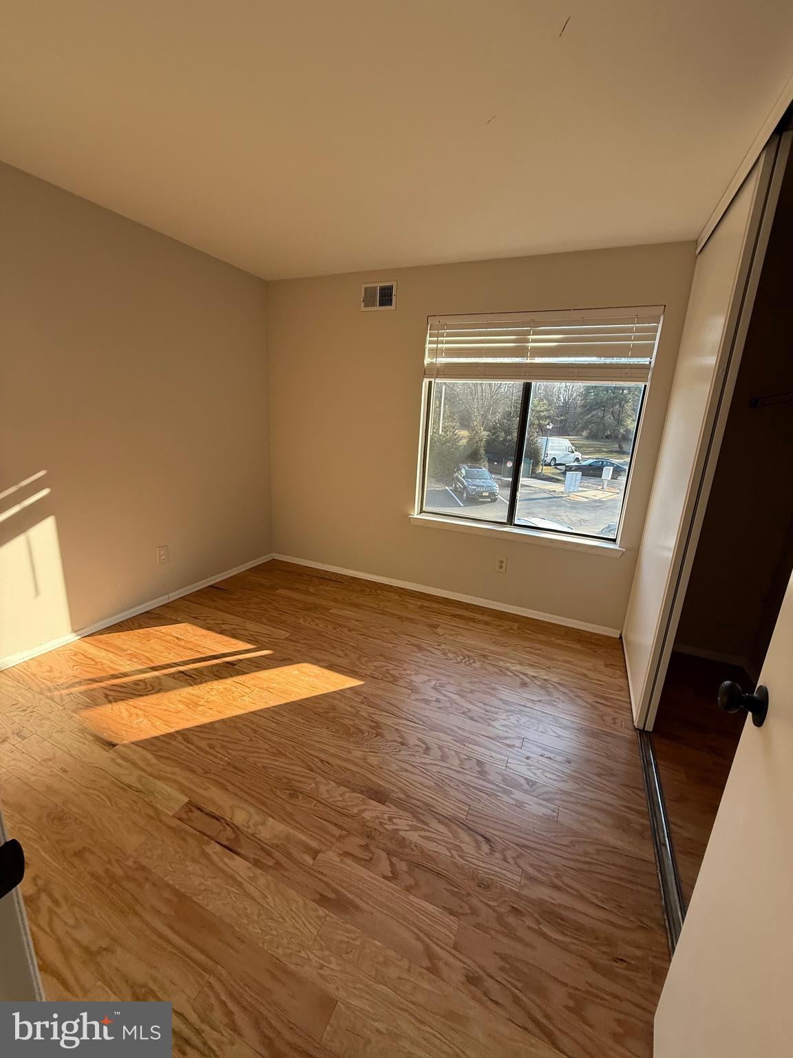 1902 The Woods Cherry Hill, NJ 08003 - Photo 10 of 17 an empty room with wooden floor and windows