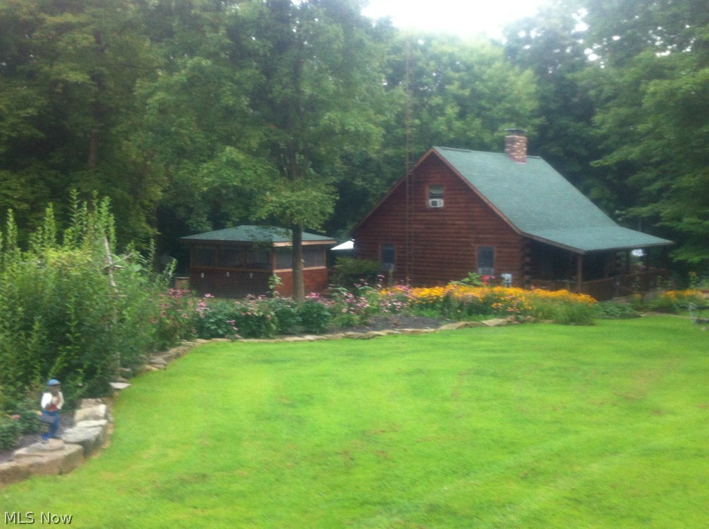 8097 Thomas Road Lisbon, OH 44432 - Photo 2 of 22 Side view of home showing beautiful perennial gardens.