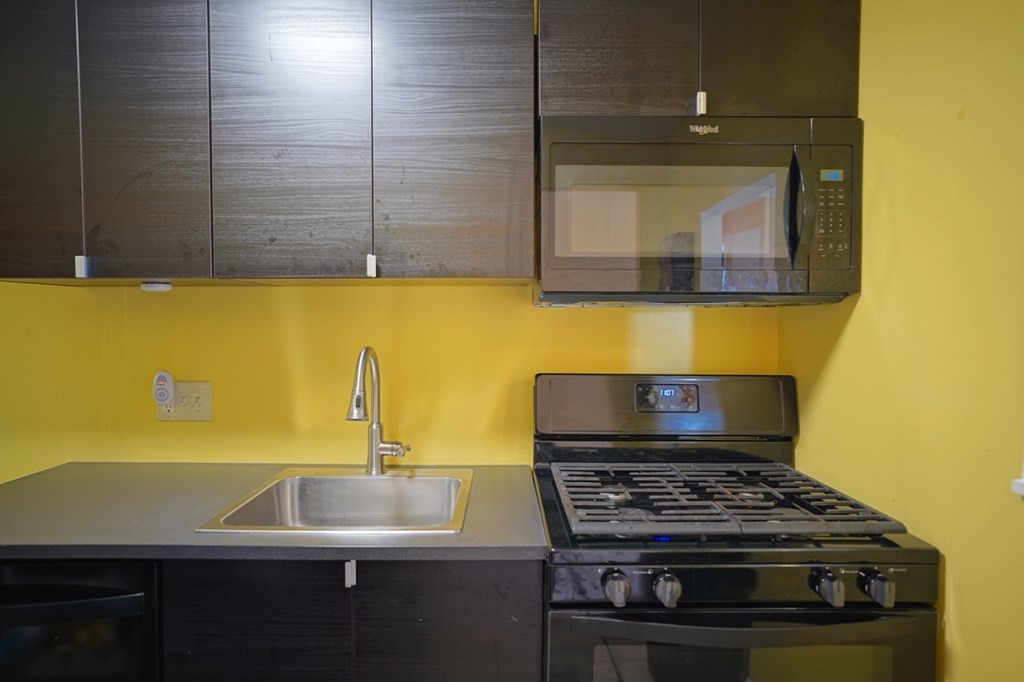 175 Clare Avenue, Unit E8 Boston, MA 02136 - Photo 7 of 25 a kitchen with a sink stove and cabinets