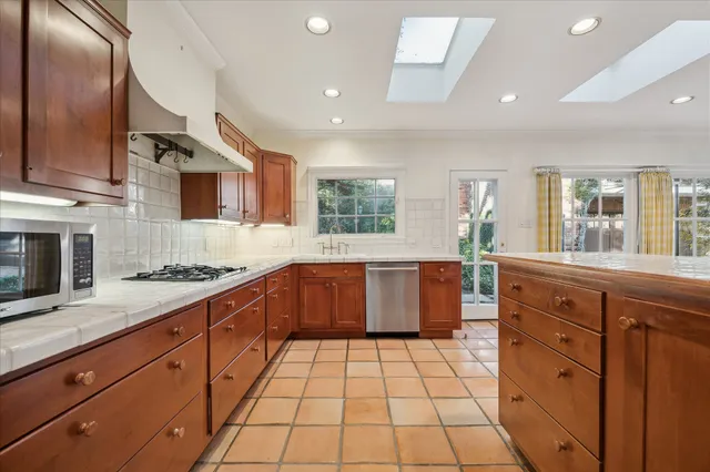 a large kitchen with stainless steel appliances granite countertop a stove a sink and a granite counter tops