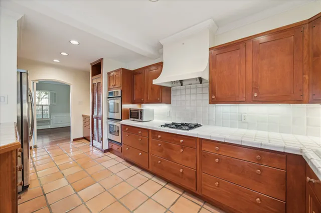 a large kitchen with stainless steel appliances granite countertop a large counter top and a stove