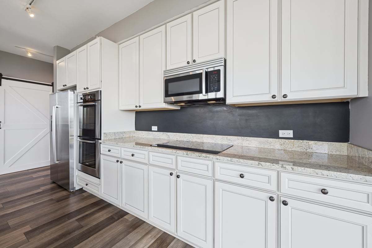 1629 South Prairie Avenue, Unit 801 Chicago, IL 60616 - Photo 9 of 33 a kitchen with granite countertop white cabinets and stainless steel appliances