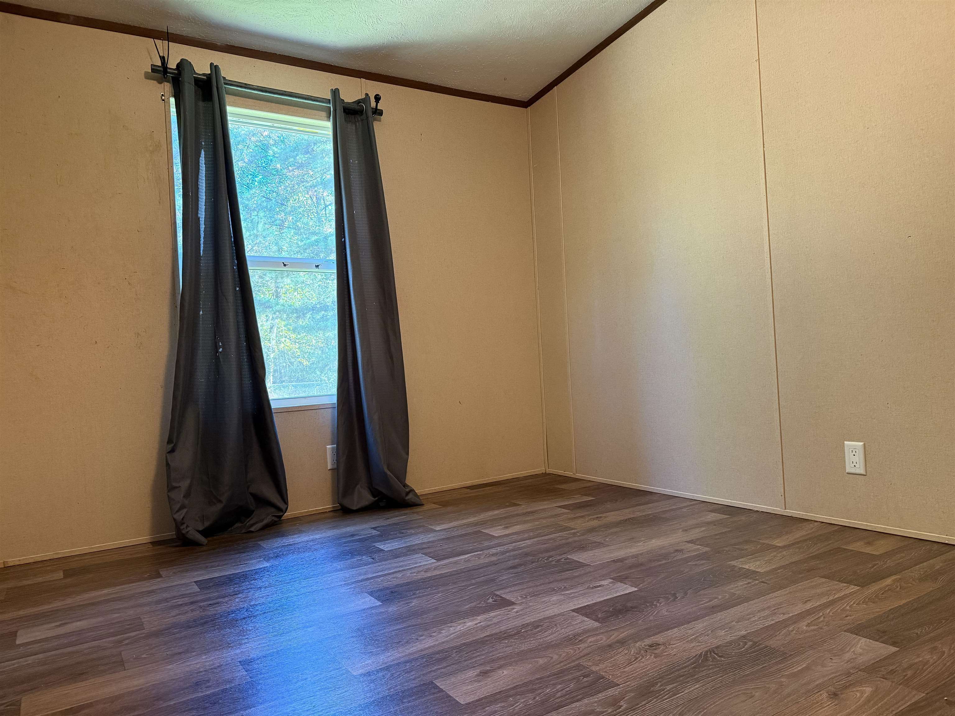 279 Travis Road Brewton, AL 36426 - Photo 13 of 17 Spare room with dark wood-style flooring and crown molding