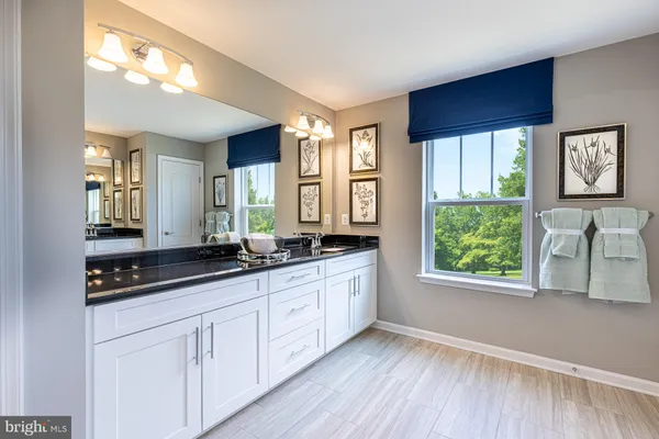 a hall with cabinets a window and wooden floor