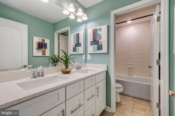 a bathroom with a granite countertop sink a toilet and shower