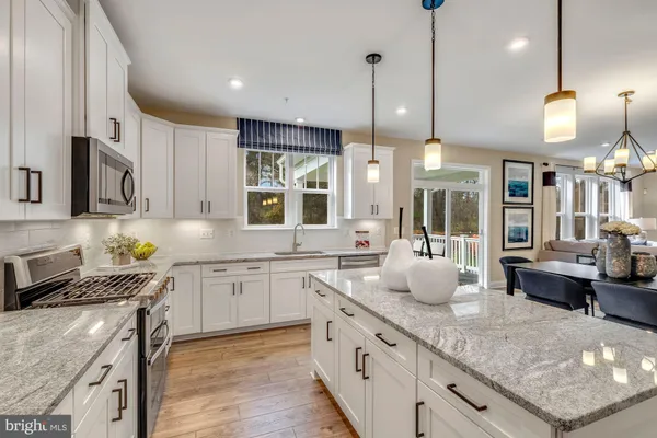 a kitchen with stainless steel appliances granite countertop wooden cabinets a stove a sink and a center island
