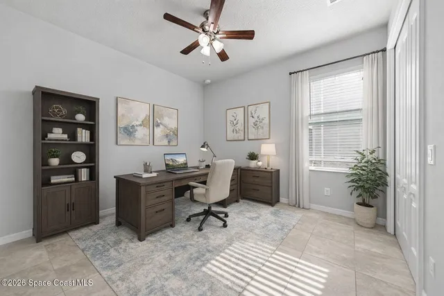 an empty room with windows and fan