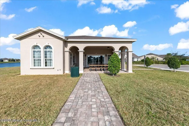 a living room with furniture floor to ceiling window and a table