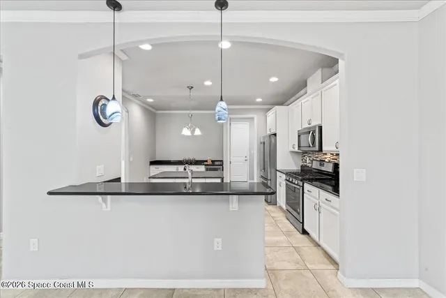 a kitchen with kitchen island stainless steel appliances a sink a center island a stove and cabinets