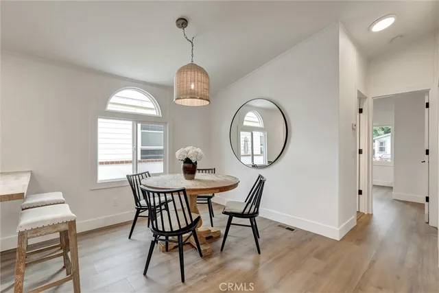 a view of a dining room with furniture a chandelier and wooden floor