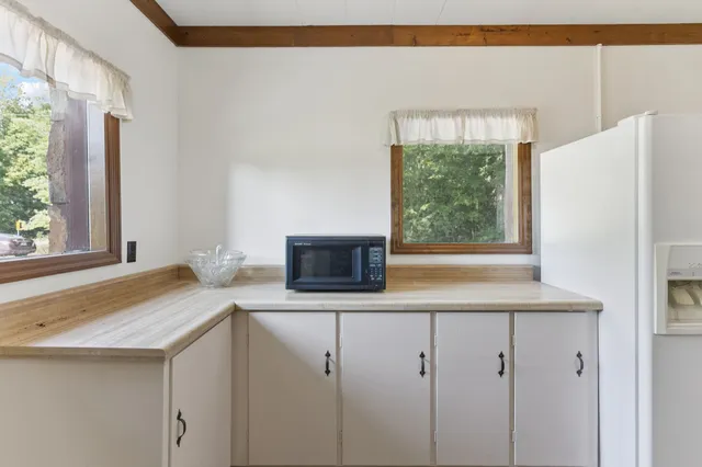a kitchen with a sink a refrigerator and a window