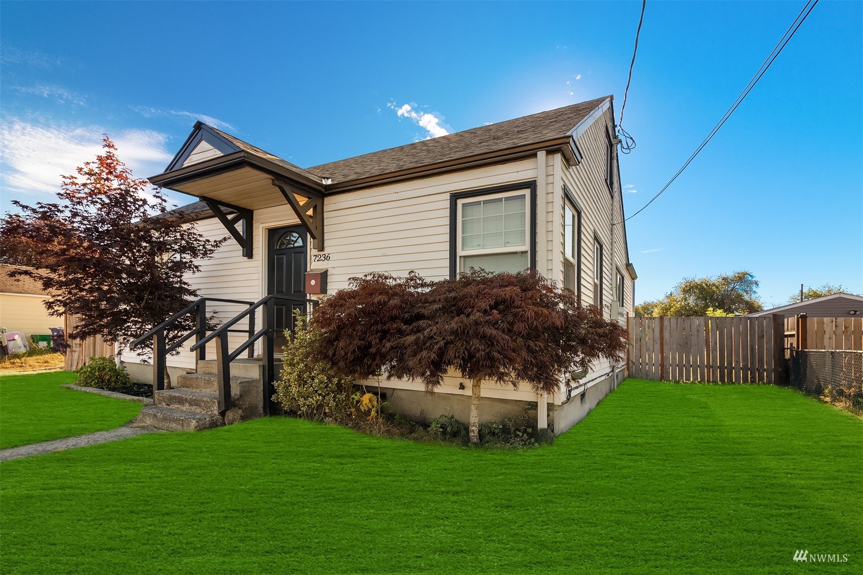 7236 South Montgomery Street Tacoma, WA 98409 - Photo 4 of 34 a front view of a house with a garden and trees