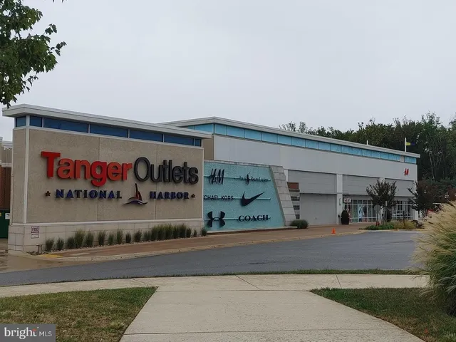 a front view of a building with retail shop and a garden