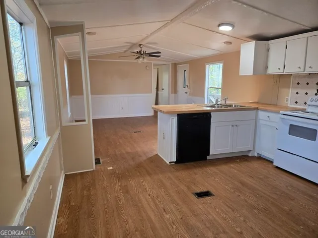 a kitchen with granite countertop a refrigerator and a stove top oven