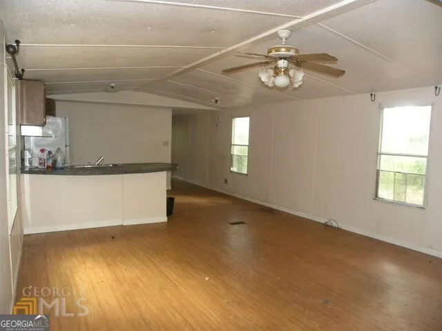 a view of a room with wooden floor and windows