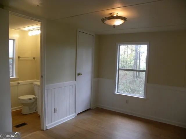 a view of an empty room with a window and bathroom