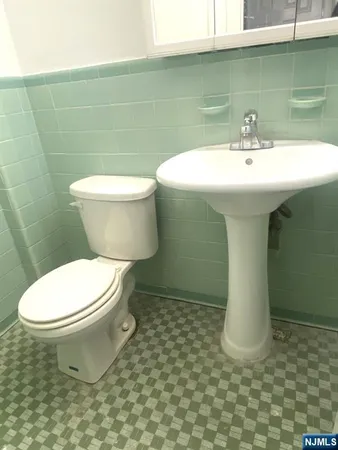 a white toilet sitting next to a bathroom sink