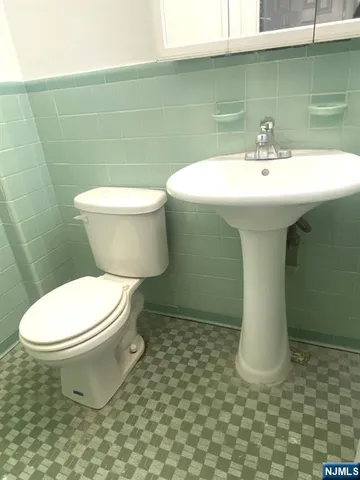 a white toilet sitting next to a bathroom sink