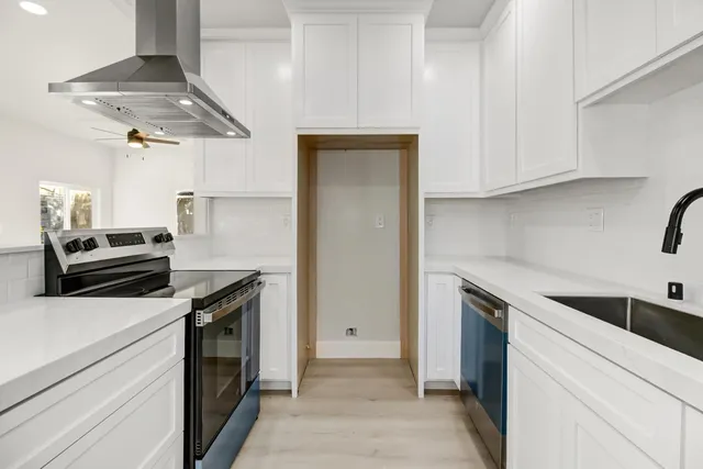 a kitchen with white cabinets and sink