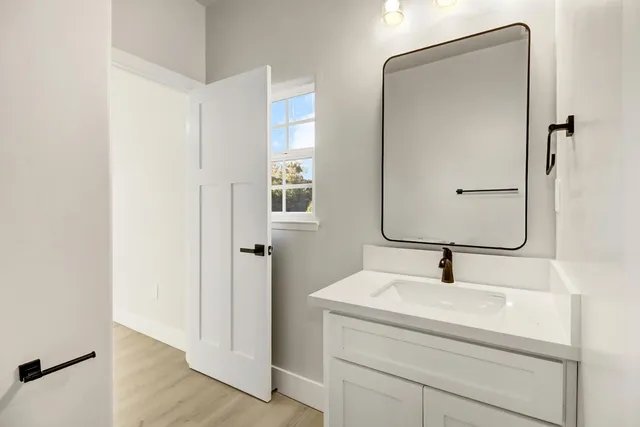 a bathroom with a sink and mirror with window