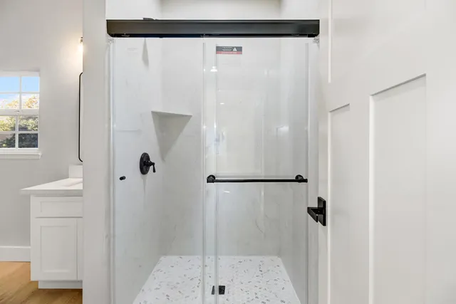 an empty room with wooden floor cabinet and windows