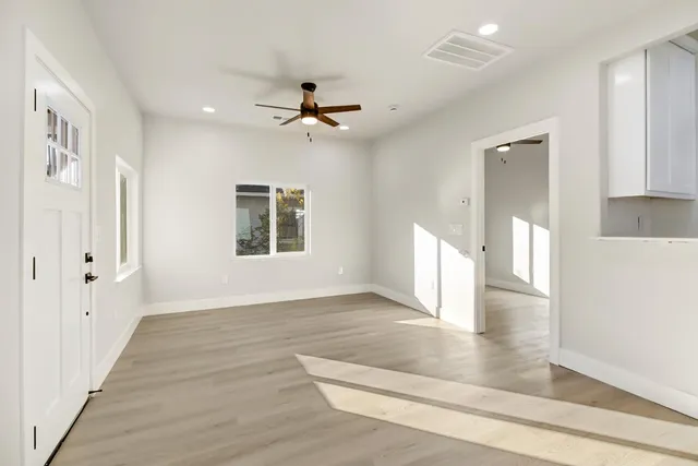 an empty room with window and ceiling fan