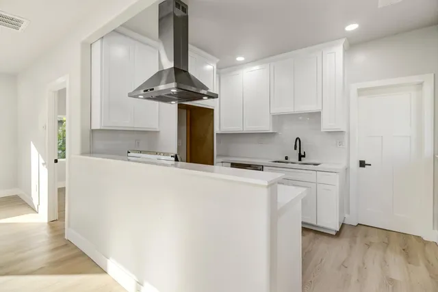 a kitchen with stainless steel appliances granite countertop a sink a stove and refrigerator